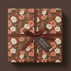 Vintage floral wrapping paper with terracotta roses and a brown ribbon, on a gift box by Wrapped Studios.