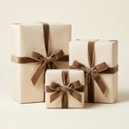 Three antique white gift boxes with brown ribbons on a light beige background
