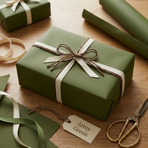Army green wrapping paper on gift box with a bow on a wooden surface, surrounded by luxury green wrapping paper and ribbons. A tag says "Army Green" next to gift.
