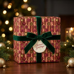 Luxury Christmas wrapping paper with a red and gold retro pattern and green velvet bow by Wrapped Studios.