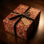 Luxury retro wrapping paper in gold and burgundy with black velvet ribbon on a gift by Wrapped Studios.