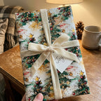 Elegant Christmas gift wrap with watercolor trees, gold ornaments, and a velvet ribbon.