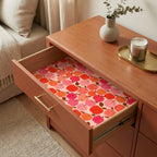 Retro pink and orange apple pattern wrapping paper lining a wooden drawer, by Wrapped Studios.