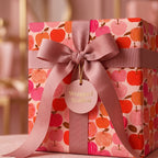 Pink apple wrapping paper on a luxury gift box with a dusty rose ribbon bow by Wrapped Studios.