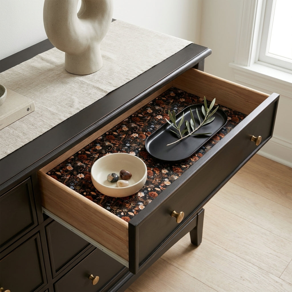 Dark botanical floral wrapping paper by Wrapped Studios lining a modern black dresser drawer.