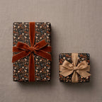 Luxury floral wrapping paper in a moody vintage design with velvet ribbon by Wrapped Studios.