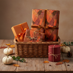 Fall gift basket with presents wrapped in leaf-patterned paper and tied with rustic twine and velvet ribbon.