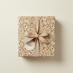Elegant gift wrapped in botanical wrapping paper with neutral ribbon and tag.