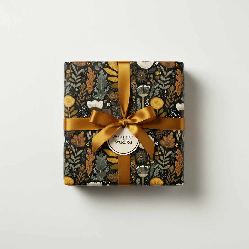 Square gift wrapped in black floral wrapping paper with a gold ribbon and bow.