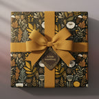 Elegant floral wrapping paper with mustard ribbon & "A little something" tag on a square gift box.