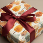 Elegant gift wrapped in autumn-themed floral wrapping paper with burgundy ribbon.