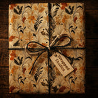 Wrapped Studios floral wrapping paper with rustic twine bow on wood surface.