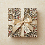 Elegant gift box in vintage floral wrapping paper with gold ribbon, perfect for birthday or special occasion.