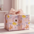 Elegant gift wrapped in pink floral wrapping paper with a sheer blush bow, perfect for birthday or baby shower presents.