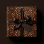 Elegant floral wrapping paper in brown with gold accents and a dark ribbon.