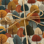 Rustic gift wrap with an autumnal tree pattern tied with gold-flecked twine.