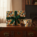 Autumn-themed gift wrap with tree pattern and green velvet ribbon, on a vintage wooden chest.
