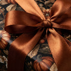 Elegant fall pumpkin wrapping paper with a copper satin ribbon bow, by Wrapped Studios.
