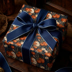 Elegant fall pumpkin and floral wrapping paper with a navy blue ribbon bow by Wrapped Studios.