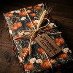 Rustic fall pumpkin wrapping paper with a twine bow and Wrapped Studios wooden tag.