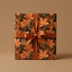 Square gift wrapped in fall-themed maple leaf paper with burnt orange ribbon.