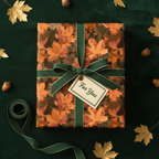 Fall gift wrap with autumn maple leaf pattern, tied with green ribbon and a "For You" tag, perfect for Thanksgiving.