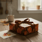 Autumn "To Mom" gift wrapped in maple leaf paper with brown velvet ribbon and card, sitting on a wooden table.