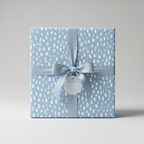 Square gift wrapped in light blue patterned paper with matching satin ribbon and bow.