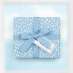 Baby blue gift box wrapped in modern minimalist wrapping paper with a "With Love" tag and matching ribbon.