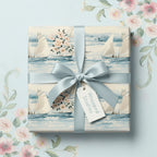 Elegant square gift wrapped in floral and sailboat pattern wrapping paper with light blue ribbon.