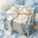 Baby shower gift wrapped in blue floral teddy bear paper with satin ribbon. "Welcome Little One" tag.