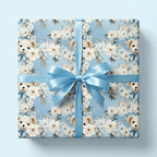 Baby shower gift wrap. Pale blue wrapping paper with bears, cream flowers, and satin blue ribbon.