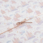 Charming fairy tale castle and rainbow wrapping paper with a delicate rose gold ribbon, perfect for a princess birthday gift.