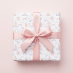 Whimsical fairytale castle and rainbow wrapping paper with a pink satin bow, perfect for a girl's birthday or baby shower gift.