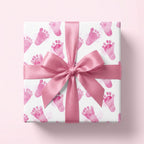 Square gift wrapped in pink baby feet wrapping paper with a matching pink satin bow, perfect for a baby shower.