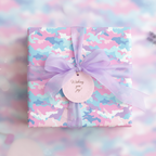 Square gift box wrapped in pastel camo wrapping paper with sheer lavender ribbon and a "Wishing you joy!" tag.