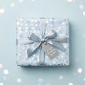 Baby blue gift box in polka dot wrapping paper with a silver ribbon, bow and gift tag.