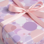 Pastel purple and pink birthday wrapping paper with modern polka dot pattern and pink satin ribbon.