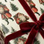 Vintage Santa Christmas wrapping paper tied with a red velvet ribbon bow by Wrapped Studios.