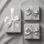 Silver cross baptism wrapping paper with white and silver satin bows by Wrapped Studios.