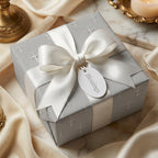 Silver cross baptism wrapping paper with a white satin bow and Blessings tag by Wrapped Studios.