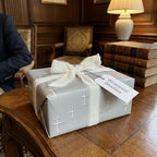 Elegant silver cross wrapping paper with a white frayed ribbon for baptism gifts by Wrapped Studios.