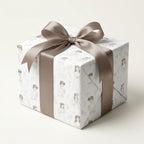 First Communion wrapping paper with vintage religious illustrations and a taupe satin bow by Wrapped Studios.