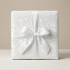 White baptism wrapping paper with vintage angels and crosses and a satin bow by Wrapped Studios.