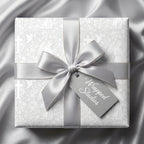 Elegant baptism wrapping paper with silver crosses and angels, tied with a satin ribbon by Wrapped Studios.