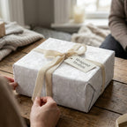 Religious wrapping paper with elegant white crosses and angels, tied with cream velvet ribbon by Wrapped Studios.