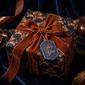 Elegant navy and gold damask luxury gift wrap with a velvet ribbon by Wrapped Studios.