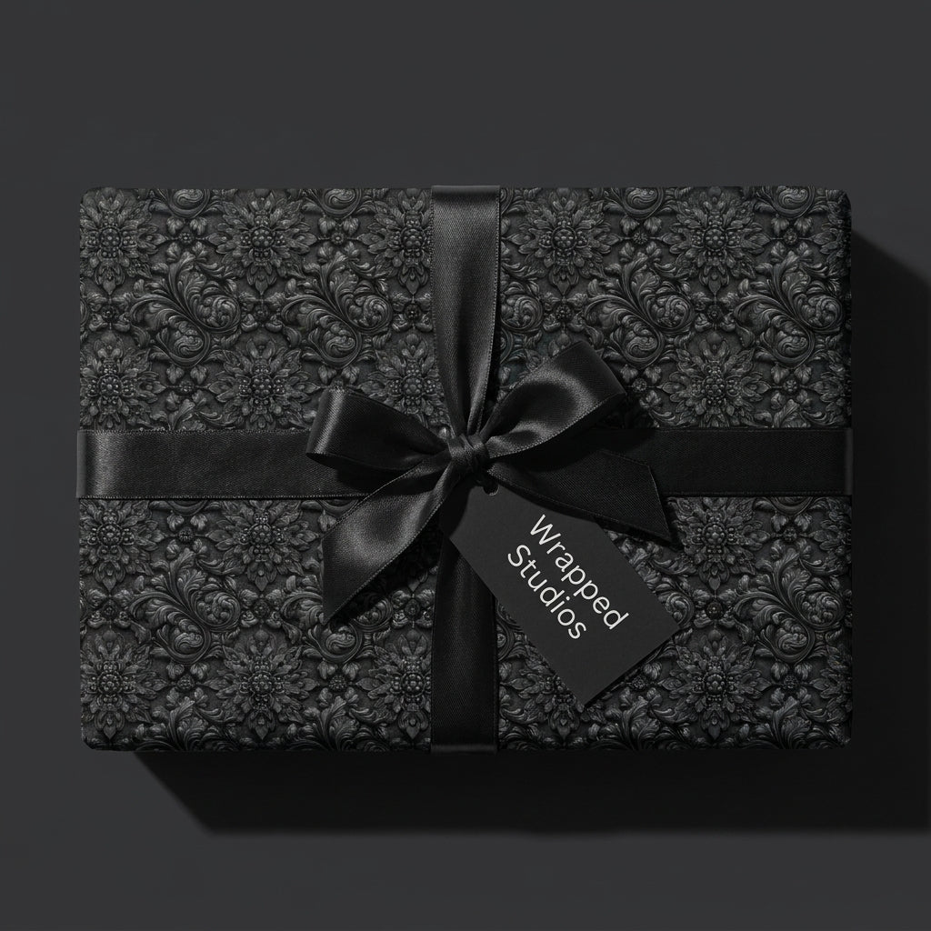 Luxury black gothic floral wrapping paper with a satin bow and gift tag by Wrapped Studios.