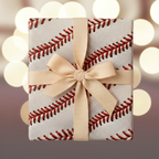 Square gift wrapped in baseball stitch patterned wrapping paper with a cream-colored ribbon and bow.