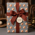 Vintage baseball wrapping paper on a gift box with a brown bow, sports gift wrap by Wrapped Studios.